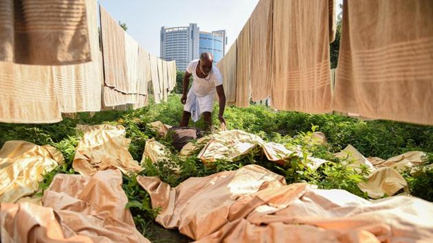 A worker prepares to hang freshly washed sheets next to drying towels at a laundry facility in New Delhi on September 12, 2018. (Noemi Cassanelli / AFP) 