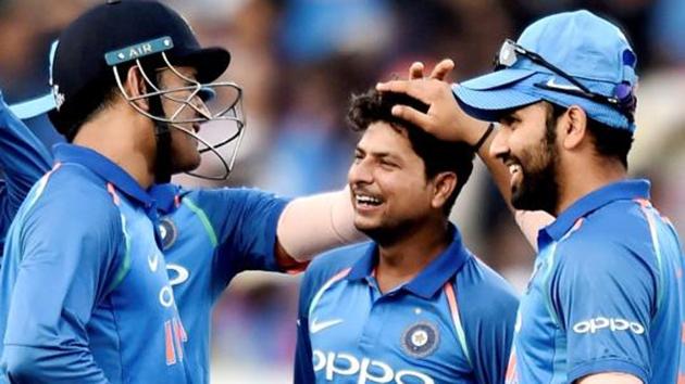 File image of Kuldeep Yadav (C) celebrating the fall of a wicket with his teammates.(PTI)