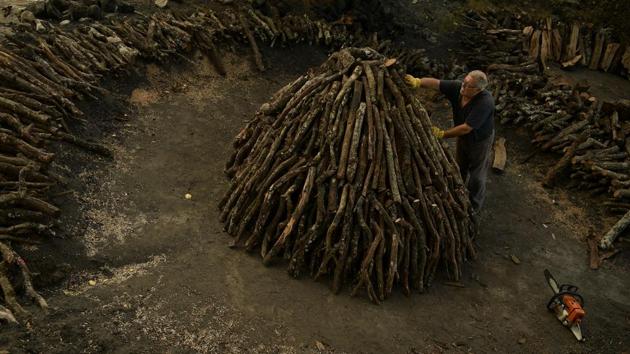 Jose Mari Nieva, 60, makes a mountain with tree trunks as part of the process to produce traditional charcoal. Charcoal pyres were once part of the landscape, and mystery shrouded the charcoal makers who, before vehicles could bring the wood all the way down to the valley, spent weeks or even months up in the mountains tending the firewood piles. (Alvaro Barrientos / AP) Jose Mari Nieva, 60, makes a mountain with tree trunks as part of the process to produce traditional charcoal. Charcoal pyres were once part of the landscape, and mystery shrouded the charcoal makers who, before vehicles could bring the wood all the way down to the valley, spent weeks or even months up in the mountains tending the firewood piles. (Alvaro Barrientos / AP)