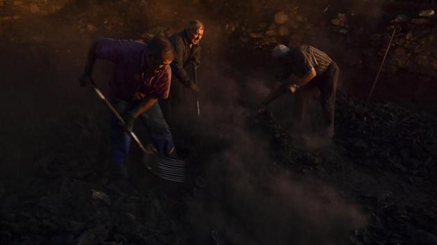 Jesus Luis Remiro (C), picks up charcoal with his brother, Salvador (R), and Jose Mari Nieva (L), as part of a process to produce traditional charcoal in Viloria, northern Spain. Only a handful of professional “charcoal cookers,” which is how locals call the back-breaking and patience exhausting process of turning firewood into lightweight pieces of carbon, remain active in Spain's northern Basque valleys. (Alvaro Barrientos / AP) Jesus Luis Remiro (C), picks up charcoal with his brother, Salvador (R), and Jose Mari Nieva (L), as part of a process to produce traditional charcoal in Viloria, northern Spain. Only a handful of professional “charcoal cookers,” which is how locals call the back-breaking and patience exhausting process of turning firewood into lightweight pieces of carbon, remain active in Spain's northern Basque valleys. (Alvaro Barrientos / AP)