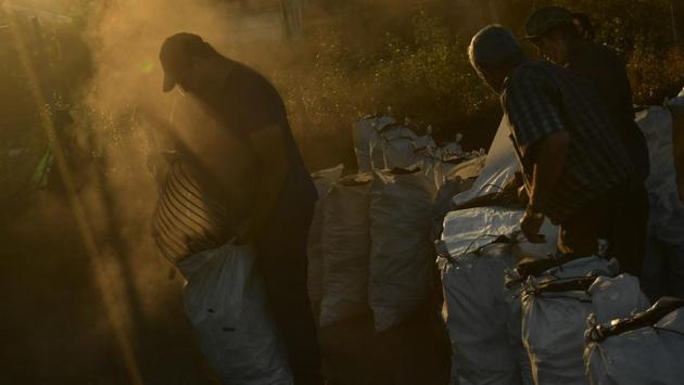 Arkaitz Lander, 22, picks up charcoal to put into sacks. Shrouded in mystery, these charcoal makers were often perceived as sullen and solitary, but also central members of the community, providing a basic necessity. (Alvaro Barrientos / AP) Arkaitz Lander, 22, picks up charcoal to put into sacks. Shrouded in mystery, these charcoal makers were often perceived as sullen and solitary, but also central members of the community, providing a basic necessity. (Alvaro Barrientos / AP)