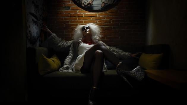 A drag performer poses for a picture while seated on a sofa at a bar in Beijing, China. (Wang Zhao / AFP)