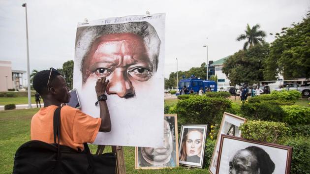 An artist paints a portrait of Kofi Annan at the entrance of Accra International Conference Centre in Accra, where the coffin of the Ghanaian diplomat and former Secretary General of United Nations who died on August 18 at the age of 80 after a short illness laid until his funeral. (Christina Aldehuela / AFP)