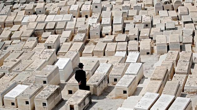 An Ultra Orthodox man mourns on tombs at the Jewish cemetery on the Mount of Olives in front of the Jerusalem’s Old City. (Thomas Coex / AFP)