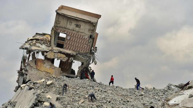 People salvage construction material at a demolition site with precariously tilting rubble after government bulldozers knocked down a mall said to be illegal for having been built on a river bed in the Kenyan capital, Nairobi. (Tony Karumba / AFP)