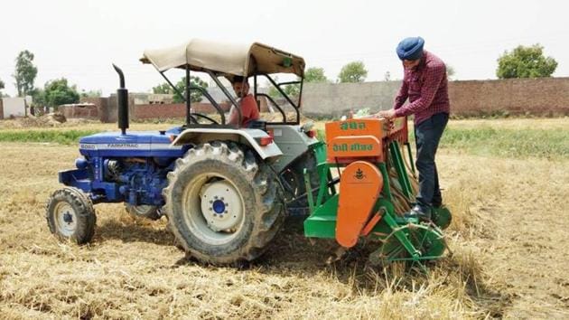 Farmers using happy seeder machine to manage stubble at Bhoewal village in Amritsar.(HT Photo)