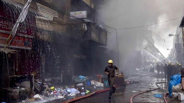 Firefighters try to douse a fire that broke out in a multi-storied wholesale Bagree market, at Burrabazar in Kolkata on Sunday.(PTI)