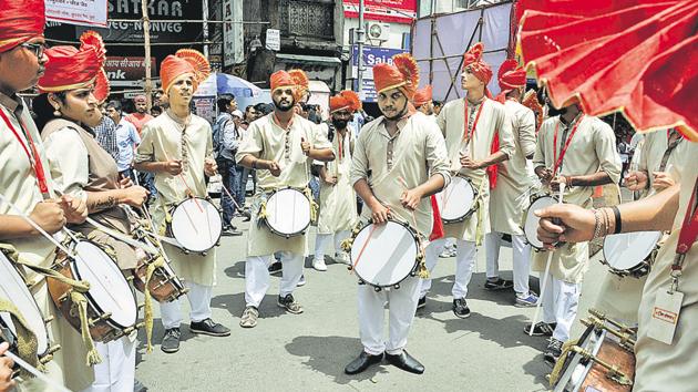 Members of a dhol tasha pathak playing the tasha, a form of kettle drum, during the Ganpati festival procession on Laxmi road. (HT PHOTO) 