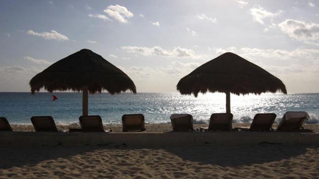 Umbrellas stand over lounge chairs next to the Caribbean Sea in the Hotel Zone of Cancun, Mexico. (BLOOMBERG) Umbrellas stand over lounge chairs next to the Caribbean Sea in the Hotel Zone of Cancun, Mexico. (BLOOMBERG)