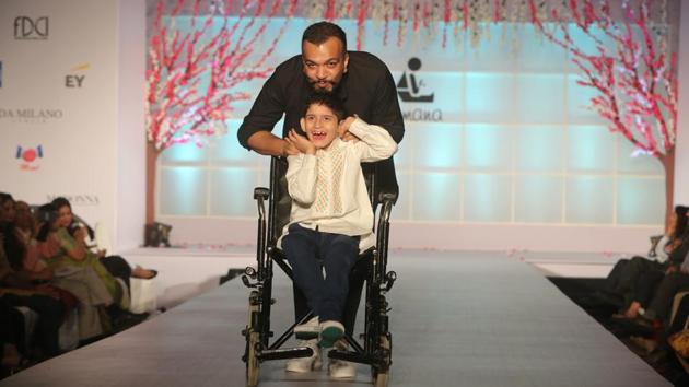 Designer Amit Aggarwal walks the ramp along with one of the students from Tamana.