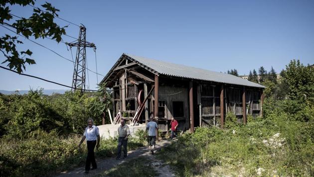 People near a cable car station in Chiatura. Some of the stations where the cars start and end are in semi-ruin, with chunks of masonry missing and their Soviet-era decorations fading. (Evgeniy Maloletka / AP) People near a cable car station in Chiatura. Some of the stations where the cars start and end are in semi-ruin, with chunks of masonry missing and their Soviet-era decorations fading. (Evgeniy Maloletka / AP)