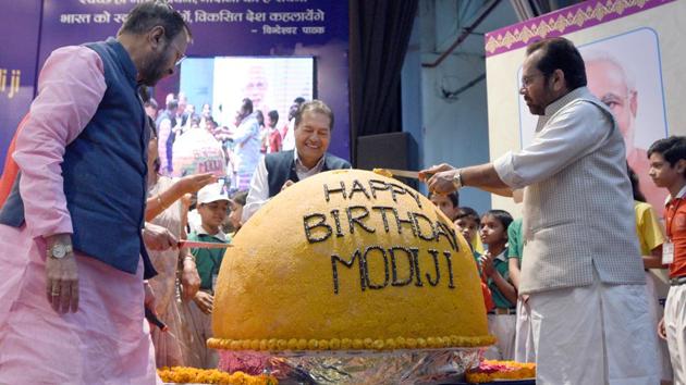 HRD minister Prakash Javadekar and minority affairs minister Mukhtar Abbas Naqvi at the unveiling of a 568 kg laddoo on PM Modi’s 68th birthday.(Sonu Mehta/HT Photo)