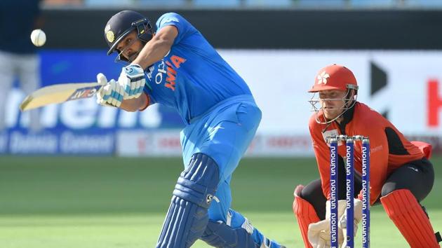 Indian cricket team captain Rohit Sharma (L) plays a shot as Hong Kong wicketkeeper Scott McKechnie looks on. (AFP)