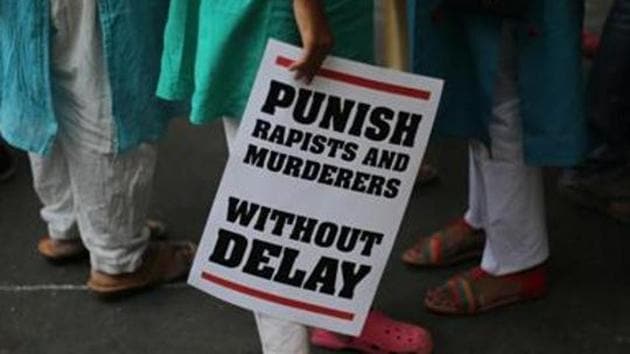 A protestor stands with a placard during a protest near parliament in New Delhi in this file photo.(AP)