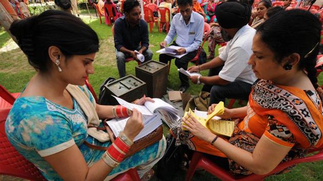 Officials on duty counting ballet papers for the zila parishad elections. A total of 62,000 ballot boxes have been arranged for the polling. The employees on election duty were handed over the election material a day before the polling.  (Pardeep Pandit/HT ) 