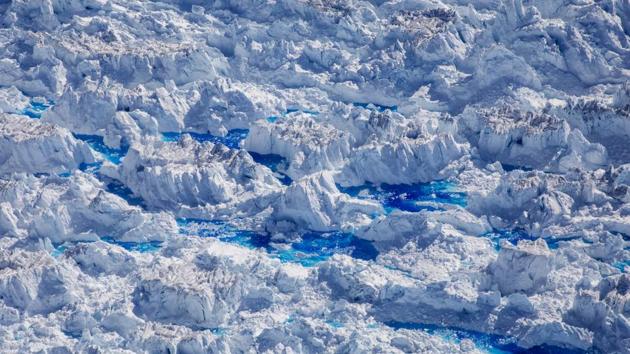 Meltwater pools are seen on top of the Helheim glacier near Tasiilaq. More explosions followed. The popping sounds morphed into a low rumble. Over the next half hour, the ice broke apart and a four-mile wide chunk tumbled into the sea in a process called calving - one rarely witnessed on this scale. (Lucas Jackson / REUTERS) Meltwater pools are seen on top of the Helheim glacier near Tasiilaq. More explosions followed. The popping sounds morphed into a low rumble. Over the next half hour, the ice broke apart and a four-mile wide chunk tumbled into the sea in a process called calving - one rarely witnessed on this scale. (Lucas Jackson / REUTERS)