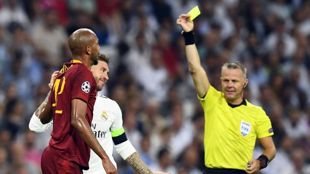 Real Madrid defender Sergio Ramos (in white) is shown a yellow card by Dutch referee Bjorn Kuipers at the Santiago Bernabeu Stadium in Madrid.(AFP)