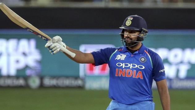 India's captain Rohit Sharma raises his bat to celebrate scoring fifty. (AP)