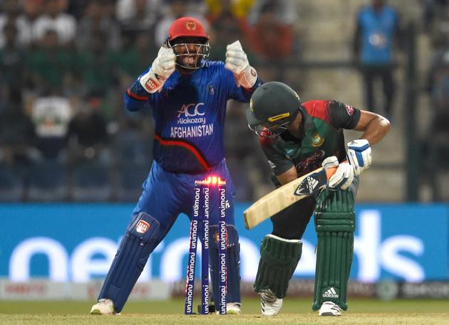Afghan wicket-keeper Mohammad Shahzad (L) celebrates as Bangladesh batsman Mohammad Mahmudullah (C) is dismissed by Afghan bowler Rashid Khan during the one day international (ODI) Asia Cup cricket match between Bangladesh and Afghanistan at The Sheikh Zayed Stadium in Abu Dhabi. (AFP)