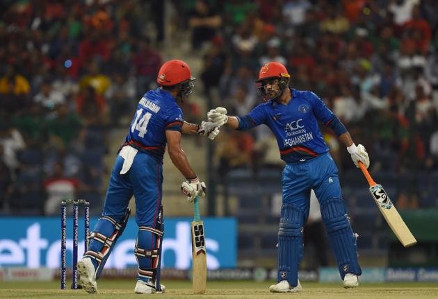 Afghan batsman Gulbadin Naib (L) and teammate Rashid Khan greet each other during the one day international (ODI) Asia Cup cricket match between Bangladesh and Afghanistan at the Sheikh Zayed Stadium in Abu Dhabi. (AFP)