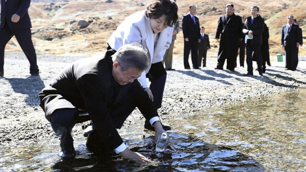 South Korean President Moon Jae-in puts water from the crater lake into a bottle as his wife Kim Jung-sook looks on. The president has long stated that visiting Mount Paektu was a “long unfulfilled dream.” “Many people in the South would go to Mount Paektu from the China side, but I decided not to, pledging myself that I would go stepping on our soil,” Moon told Kim after reaching the peak. (David Guttenfelder / AP) South Korean President Moon Jae-in puts water from the crater lake into a bottle as his wife Kim Jung-sook looks on. The president has long stated that visiting Mount Paektu was a “long unfulfilled dream.” “Many people in the South would go to Mount Paektu from the China side, but I decided not to, pledging myself that I would go stepping on our soil,” Moon told Kim after reaching the peak. (David Guttenfelder / AP)