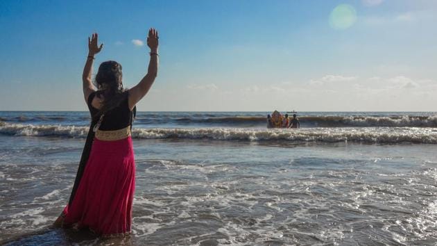 A woman prays as people carry an idol of Ganesha for immersion at Versova beach in Mumbai on September 17, 2018. (Ragul Krishnan / HT Photo) A woman prays as people carry an idol of Ganesha for immersion at Versova beach in Mumbai on September 17, 2018. (Ragul Krishnan / HT Photo)