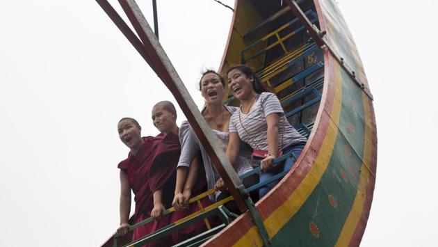 Exiled Tibetan Buddhist nuns along with others enjoy a ride on a pendulum swing at a local fair in Dharmsala on September 16, 2018. (Ashwini Bhatia / AP) Exiled Tibetan Buddhist nuns along with others enjoy a ride on a pendulum swing at a local fair in Dharmsala on September 16, 2018. (Ashwini Bhatia / AP)