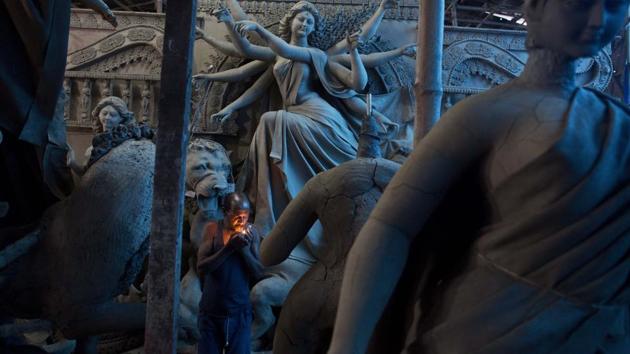 An artisan smokes as he works on idols of goddess Durga inside a workshop in Guwahati on September 20, 2018. (Anupam Nath / AP) An artisan smokes as he works on idols of goddess Durga inside a workshop in Guwahati on September 20, 2018. (Anupam Nath / AP)