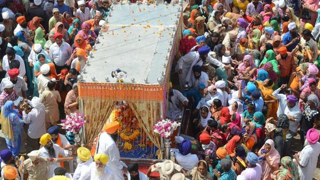 Sikh devotees pay their respect to the Palki Sahib in which the Guru Granth Sahib -- the Sikh Holy book -- is placed during a procession to mark Guru Nanak Dev's marriage anniversary in Batala, Amritsar on September 16, 2018. (Narinder Nanu / AFP) Sikh devotees pay their respect to the Palki Sahib in which the Guru Granth Sahib -- the Sikh Holy book -- is placed during a procession to mark Guru Nanak Dev's marriage anniversary in Batala, Amritsar on September 16, 2018. (Narinder Nanu / AFP)