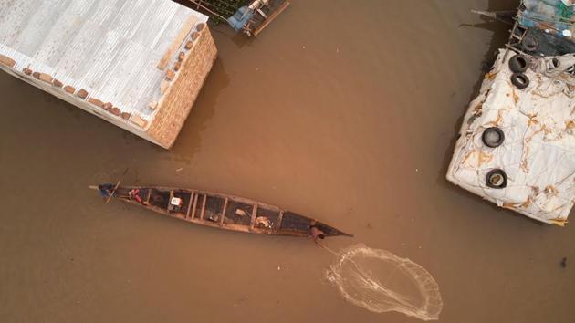 A Malian fisherman throws his fishing net next to his flooded village on the outskirts of the capital Bamako, Mali. Due to heavy rains the Niger overflowed, flooding several villages located on its edge. (Michelle Cattani / AFP)