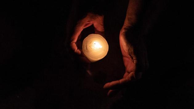 A member of the Pueblos Sin Fronteras, a pro-immigration advocacy group, lights a candle during a vigil to raise awareness of local police harassment and abuse of migrants, deported migrants and homeless in Tijuana, Baja California state, Mexico. (Guillermo Arias / AFP)