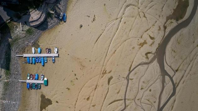 Boats are seen in the dried bed of the Brenet Lake (French: Lac des Brenets) part of the Doubs river, a natural border between eastern France and western Switzerland in Les Brenets. (Fabrice Coffrini / AFP)