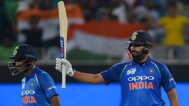 Indian Cricket team captain Rohit Sharma (R) celebrates after scoring his half-century. (AFP)
