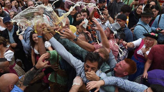 People spill a glass of beer during the opening day off the festival. This year the festival runs from September 22 to October 7. (Christof Stache / AFP) People spill a glass of beer during the opening day off the festival. This year the festival runs from September 22 to October 7. (Christof Stache / AFP)