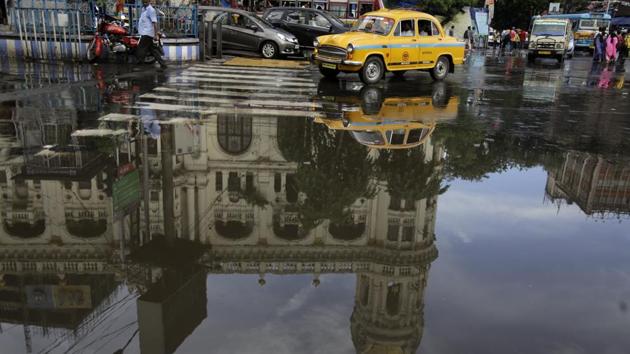 A yellow city taxi moves past as the landmark Metropolitan Building is reflected in a puddle of water created by monsoon rains in Kolkata on September 20, 2018. (Bikas Das / AP) A yellow city taxi moves past as the landmark Metropolitan Building is reflected in a puddle of water created by monsoon rains in Kolkata on September 20, 2018. (Bikas Das / AP)