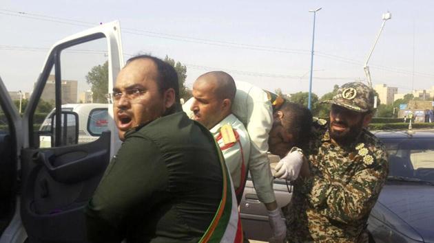 In this photo provided by the Iranian Students' News Agency, ISNA, Revolutionary Guard members carry a wounded comrade after a shooting during their parade marking the 38th anniversary of Iraq's 1980 invasion of Iran, in the southwestern city of Ahvaz, Iran, Saturday, Sept. 22, 2018.(AP)