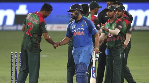 Rohit Sharma, holding bat, shakes hands with Bangladesh's captain Mashrafe Mortaza, left, as he leaves the field. (AP)