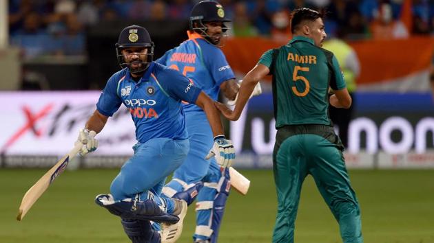 Indian cricket team captain Rohit Sharma (L) and Shikhar Dhawan runs between the wickets as Pakistan cricketer Mohammad Amir (R) looks on during the one day international (ODI) Asia Cup cricket match between Pakistan and India at the Dubai International Cricket Stadium in Dubai on September 19, 2018. (AFP) Indian cricket team captain Rohit Sharma (L) and Shikhar Dhawan runs between the wickets as Pakistan cricketer Mohammad Amir (R) looks on during the one day international (ODI) Asia Cup cricket match between Pakistan and India at the Dubai International Cricket Stadium in Dubai on September 19, 2018. (AFP)