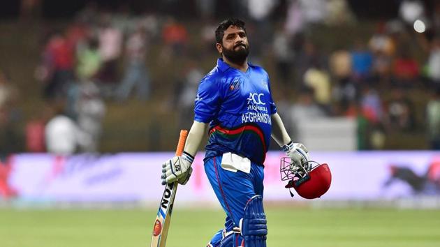 Afghanistan batsman Mohammad Shahzad (R) leaves the pitch after being dismissed during the one day international (ODI) Asia Cup cricket match between Afghanistan and Bangladesh.(AFP)