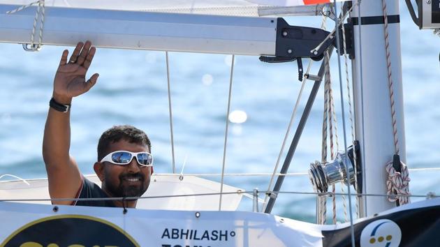 In this file photo taken on July 01, 2018 India's Abhilash Tomy gestures on his boat "Thuriya" as he sets sails from Les Sables d'Olonne Harbour at the start of the solo around-the-world ‘Golden Globe Race’ ocean race in which sailors compete without high technology aides such as GPS or computers.(AFP File Photo)