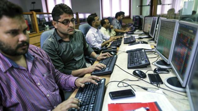 Employees work at computers at a brokerage firm in Mumbai.(Bloomberg)