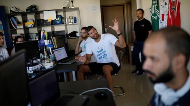 When Wamba, 17, arrived in Greece, his prospects, like thousands languishing on its islands, were dim. Then technology changed his luck. After months on Lesbos, he created a profile on Athlenda, a start-up described by its founder Lazaros Papadopoulos (C), a former Greece national team player, as “LinkedIn for athletes,” bringing together players, coaches, clubs and scouts. (Alkis Konstantinidis / REUTERS) 