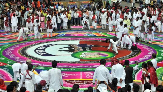 Rashtriya Kala Akadami members giving finishing touches to the rangoli made for the Ganesh visarjan procession on Laxmi road on Sunday. (ht photo) 