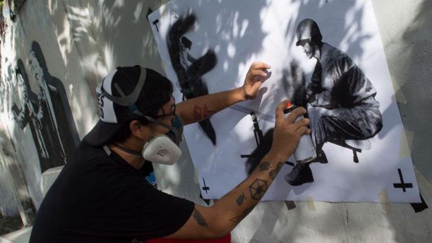Headache Stencil spray-paints a graffiti on a fence in Bangkok. Much like “Banksy”, the British graffiti artist turned multi-millionaire art auction darling, Headache’s carefully maintained mystique adds to the allure of his work. And it has caught the imagination of a country where an increasing number of people are looking to art to dissect the anti-junta angst that lurks below the surface. (Romeo Gacad / AFP) Headache Stencil spray-paints a graffiti on a fence in Bangkok. Much like “Banksy”, the British graffiti artist turned multi-millionaire art auction darling, Headache’s carefully maintained mystique adds to the allure of his work. And it has caught the imagination of a country where an increasing number of people are looking to art to dissect the anti-junta angst that lurks below the surface. (Romeo Gacad / AFP)