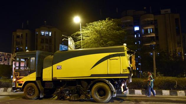 PWD worker cleaning Ring road with mechanized vacuum sweepers near Mayur vihar, in East Delhi, India on Friday Night, April 01, 2016.(HT File Photo)