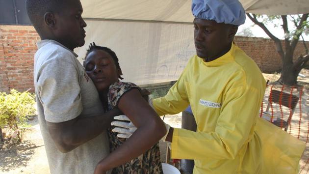 A sick woman suspected of suffering from cholera, is carried at a clinic in Harare. It’s a period of crisis for a government that pledges, somehow, to turn a collapsed economy into a middle-class one by 2030. As many residents of Harare hop-skip over fetid puddles, many are reminded of the outbreak a decade ago that killed over 4,000 people. Now water and sanitation are largely worse than before. (Tsvangirayi Mukwazhi / AP) A sick woman suspected of suffering from cholera, is carried at a clinic in Harare. It’s a period of crisis for a government that pledges, somehow, to turn a collapsed economy into a middle-class one by 2030. As many residents of Harare hop-skip over fetid puddles, many are reminded of the outbreak a decade ago that killed over 4,000 people. Now water and sanitation are largely worse than before. (Tsvangirayi Mukwazhi / AP)