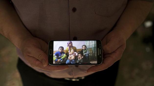 Adil, 42, father to five children and a businessman from Kashgar, China, holds a phone showing an image of his family left behind. Uighurs fear that these measures are essentially wiping out their ethnic identity, one child at a time. The camps are among the most troubling aspects of Xi’s campaign to assert the party’s dominance over all aspects of Chinese life, which has drawn comparisons with Mao Zedong. (Dake Kang / AP) 