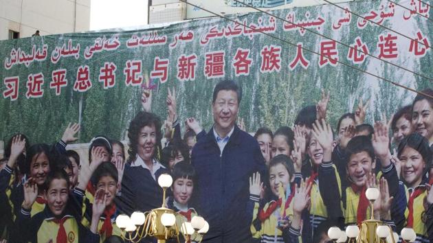 A propaganda poster reads ‘Party Secretary Xi Jinping and Xinjiang’s multi ethnic residents united heart to heart’. Authorities heeding Xi’s call to “Sinicize” religion across the country have shut underground churches, replaced pictures of Jesus with Xi’s, and toppled crescents from mosques. Xinjiang is serving as testing ground for tracking citizens. The AP interviewed 14 Uighur families in Turkey and one Kazakh man in Almaty with a total of 56 children who remain in China. (Ng Han Guan / AP) 