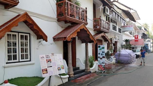 A worker cleans the entrance of a hotel, next to the signboard for OYO Rooms at Fort Kochi, Kerala.(Reuters File Photo)