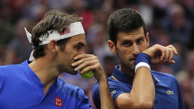 Team Europe's Roger Federer (left) whispers to Novak Djokovic during a men’s doubles tennis match against Team World’s Jack Sock and Kevin Anderson in the Laver Cup.(AP)